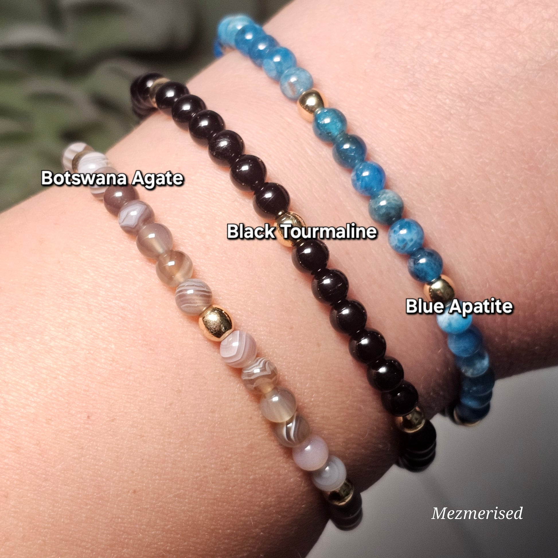 Stacked 4mm Botswana Agate, Black Tourmaline and Blue Apatite gemstone bracelets with minimalist gold accent details.