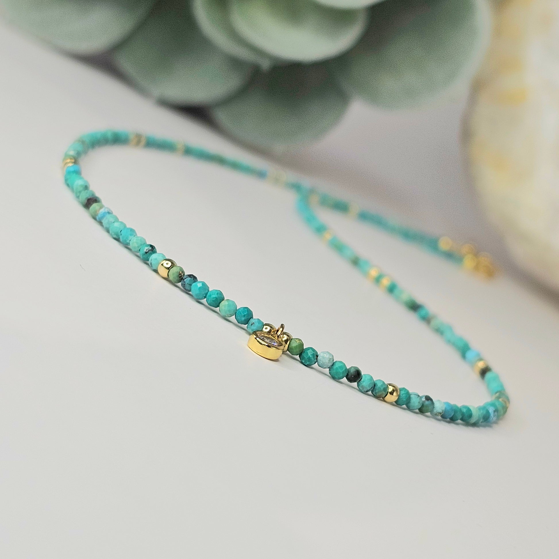 Angled view from below the pendant looking upward, highlighting the round symbol design and its connection to the surrounding Turquoise bead strand.