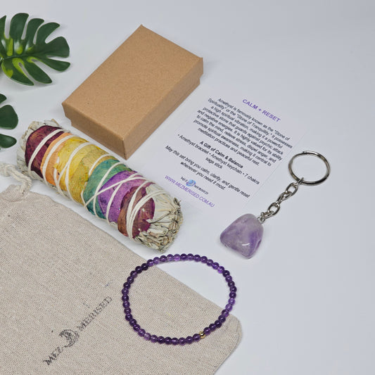 Calm & Reset crystal gift set showing all items laid out including amethyst bracelet, keychain, sage stick, info card and packaging.