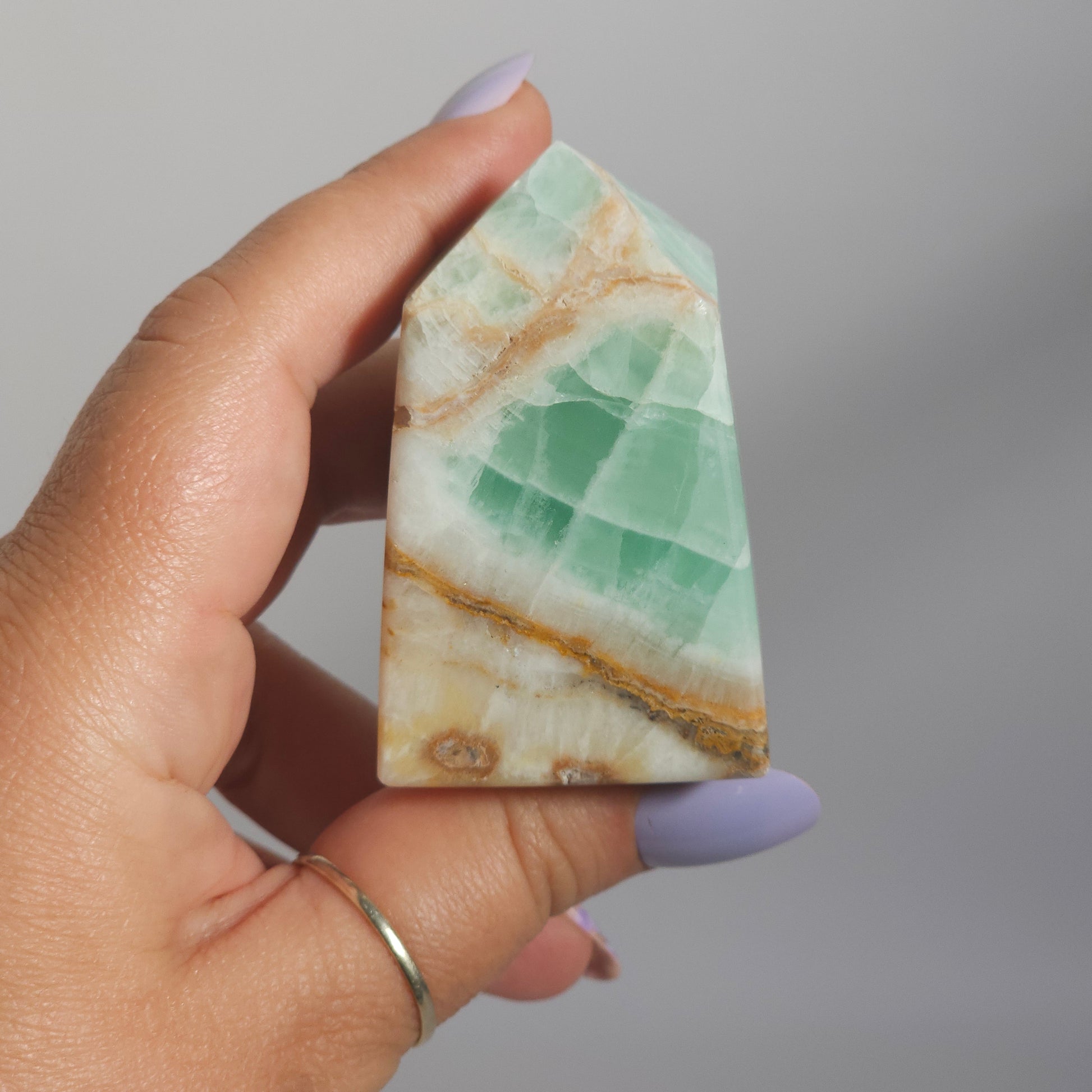 Caribbean Calcite Tower In Hand Close Up Highlighting Coastal Green Tones and Texture