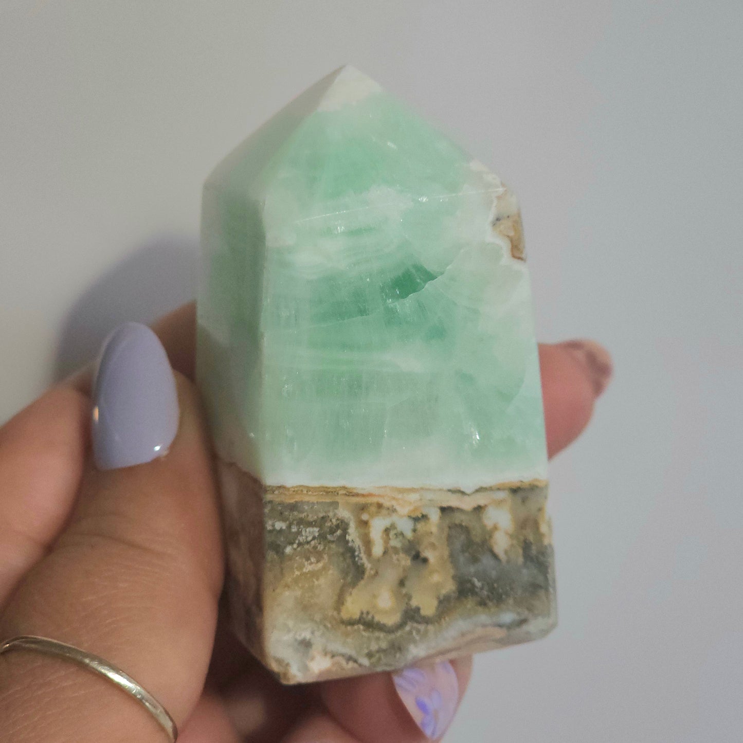 Caribbean Calcite Tower In Hand Close Up Highlighting Coastal Green Tones and Texture