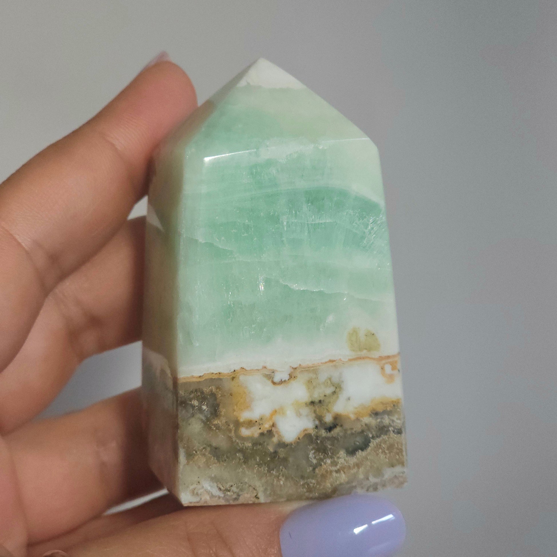 Caribbean Calcite Tower In Hand Close Up Showing Ocean Tones and Texture