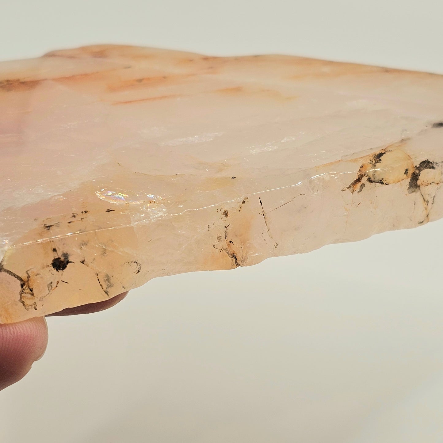 Detailed close-up of natural dendritic and iron inclusions within translucent Rose Quartz, showcasing unique organic formations and internal character.