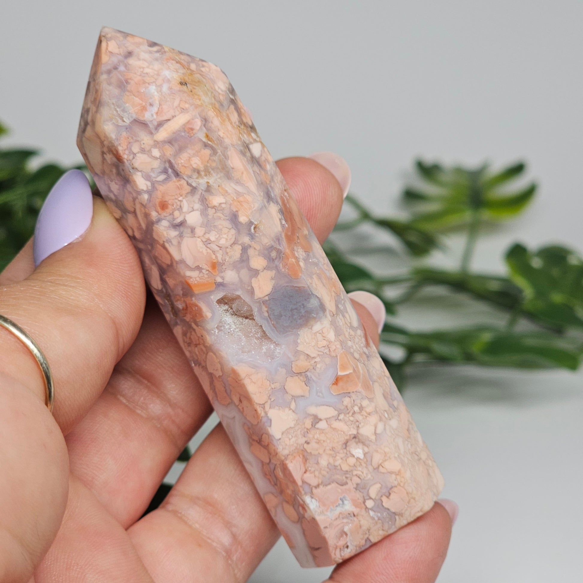 Cotton candy agate tower held in hand showing size, natural pastel pink and blue grey colouring, "shattered" pattern and sugar druzy detail