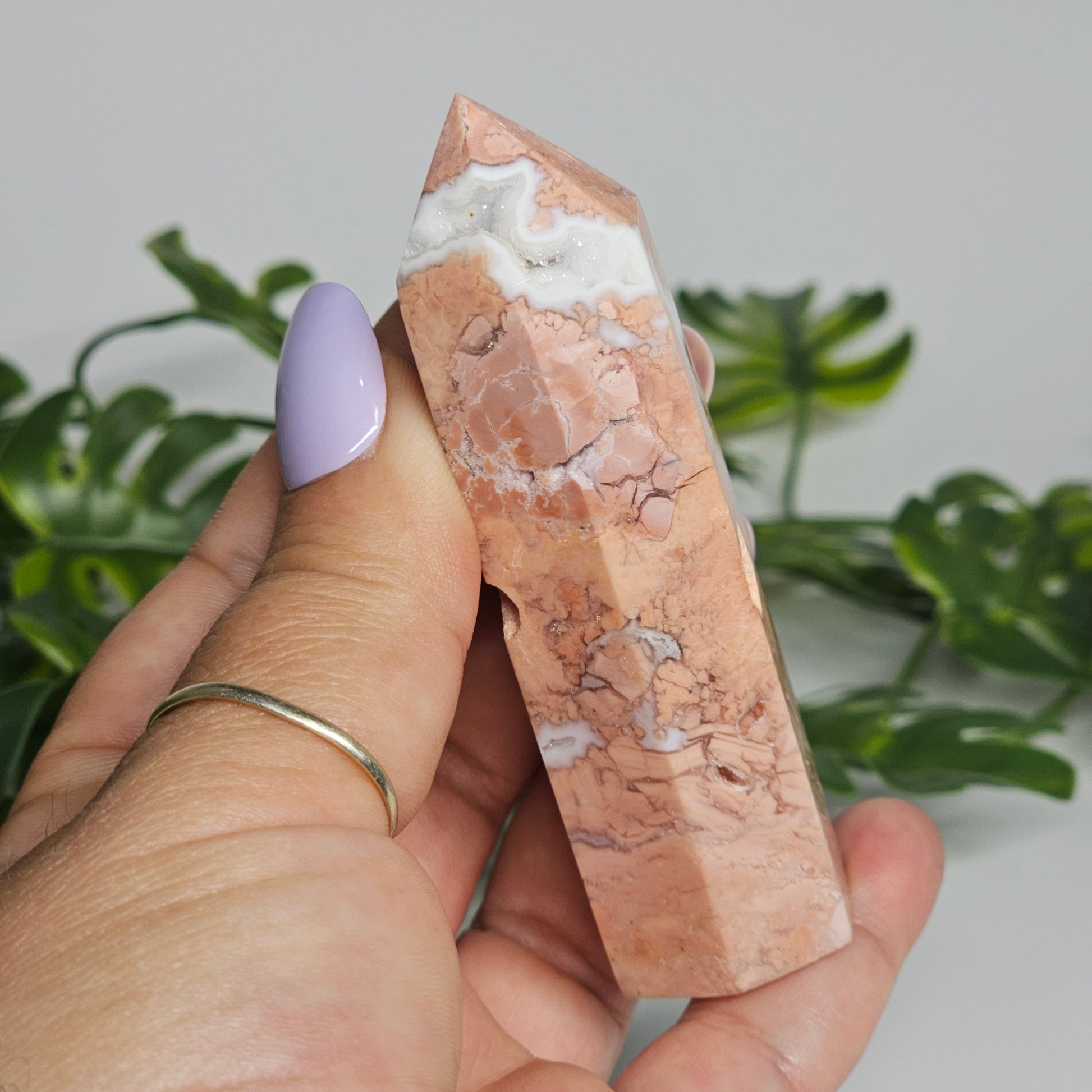 Cotton candy agate tower held in hand showing size, natural pastel colouring, and sugar druzy detail