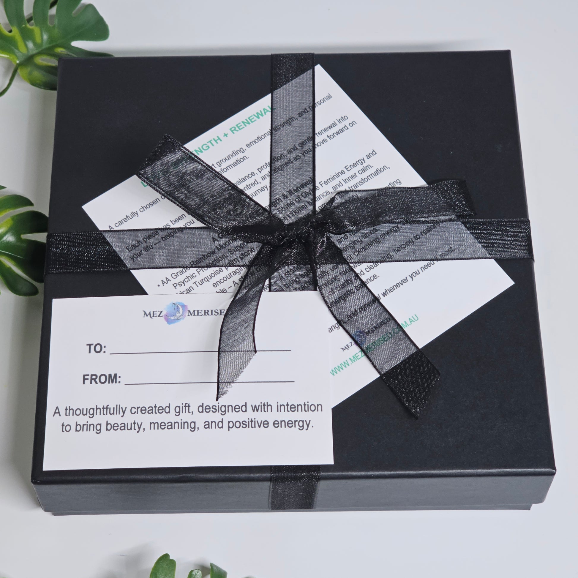 Closed crystal gift box with items inside including info card and to from gift card.