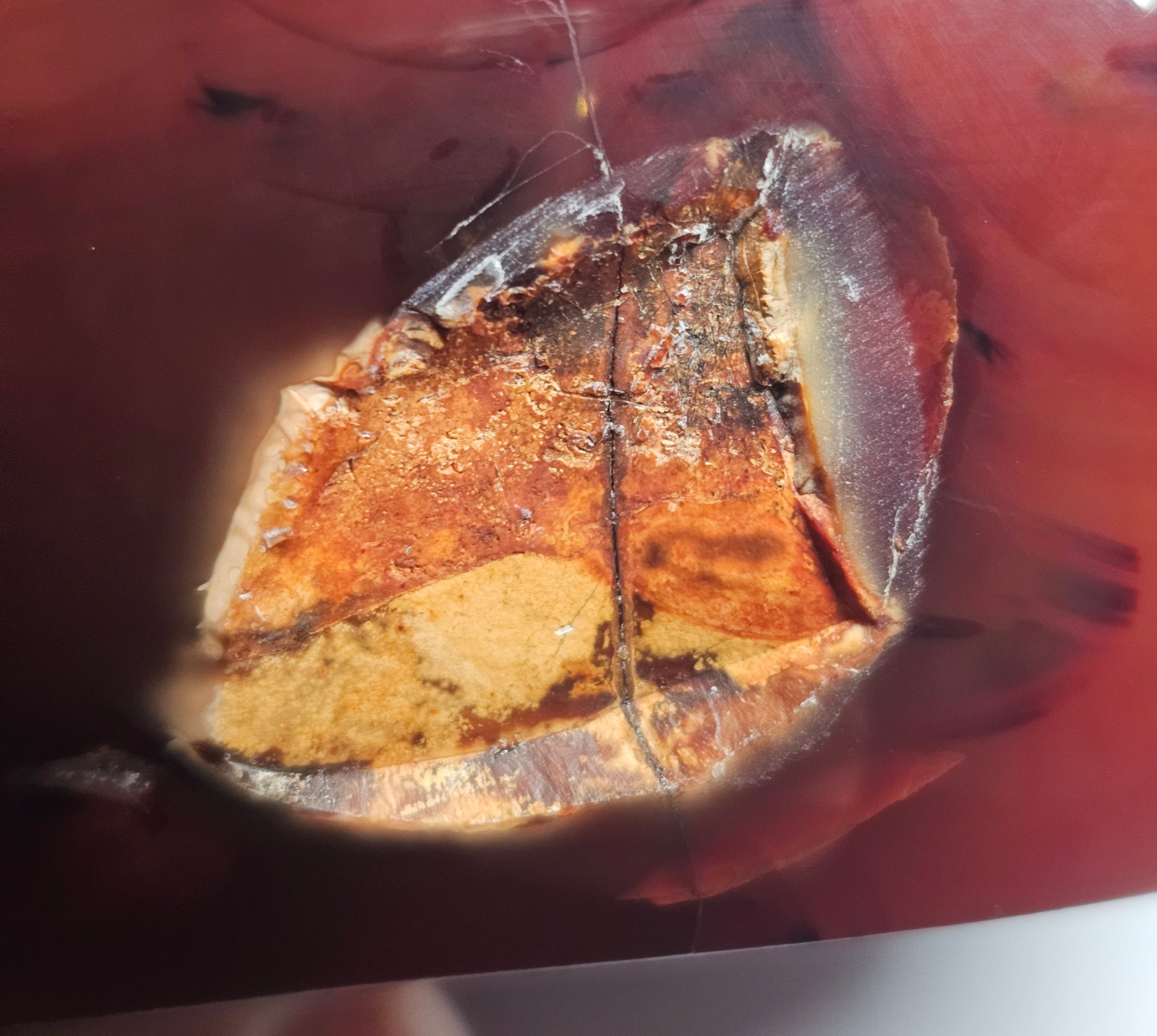 Front-facing view of the dark Carnelian crystal bowl displaying the natural indentation on the outer wall, along with the polished finish and rich Madagascan Carnelian colouring.