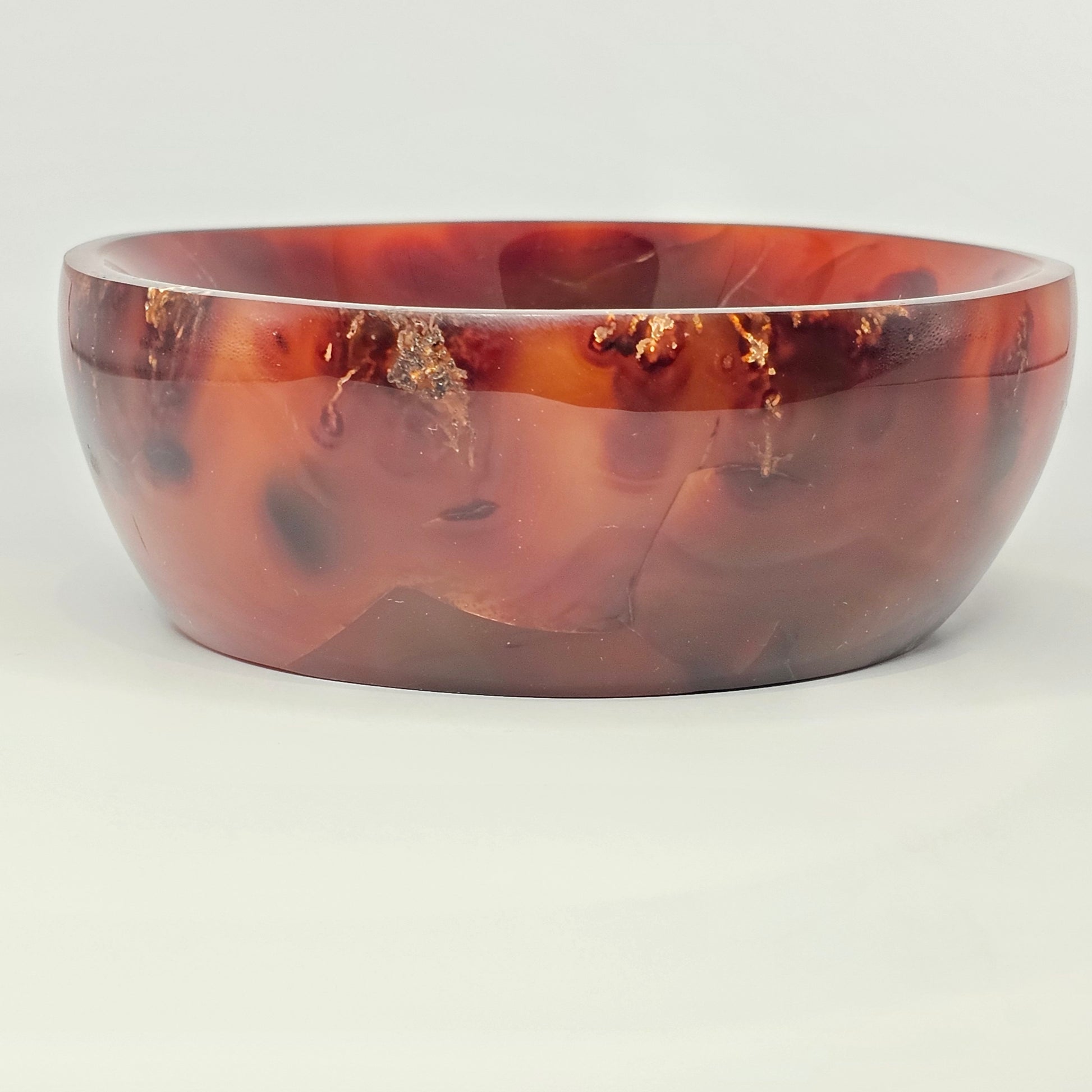 Studio lighting size view of the dark Carnelian crystal bowl displaying its polished surface, deep reddish-orange tones, and dimensional shape.