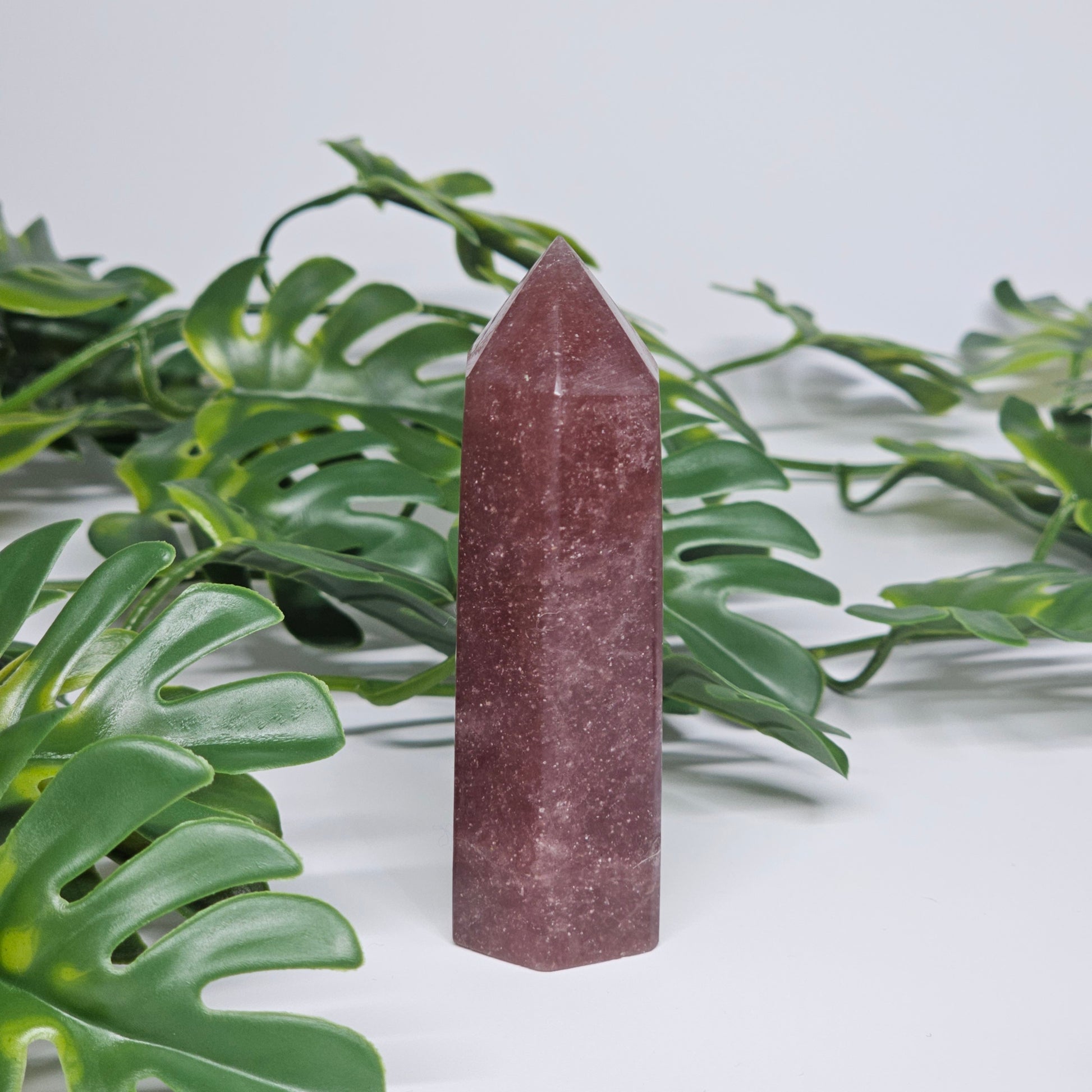 Dark strawberry quartz tower crystal showing rich pink colour and polished point
