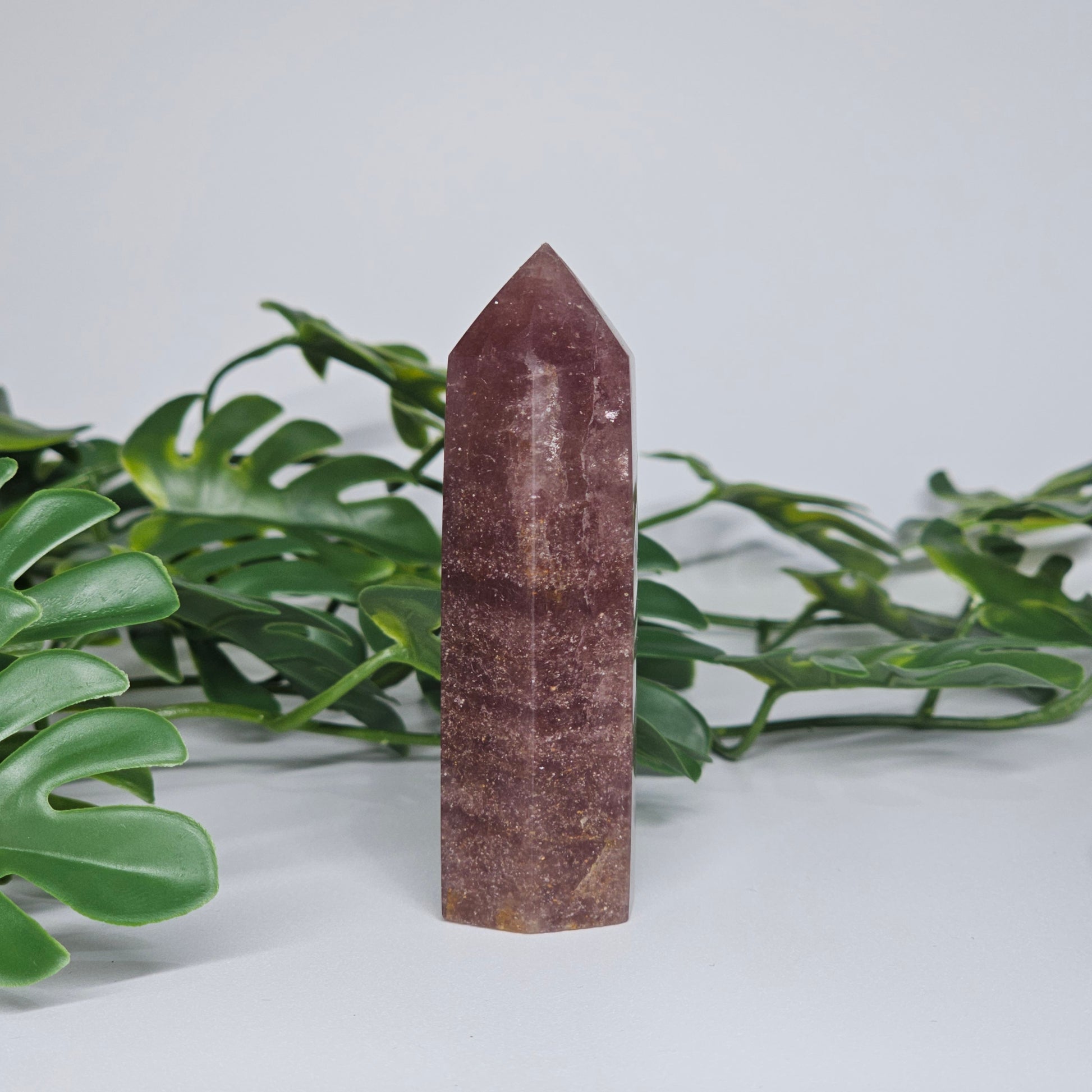 Dark strawberry quartz tower crystal showing rich pink colour and polished point