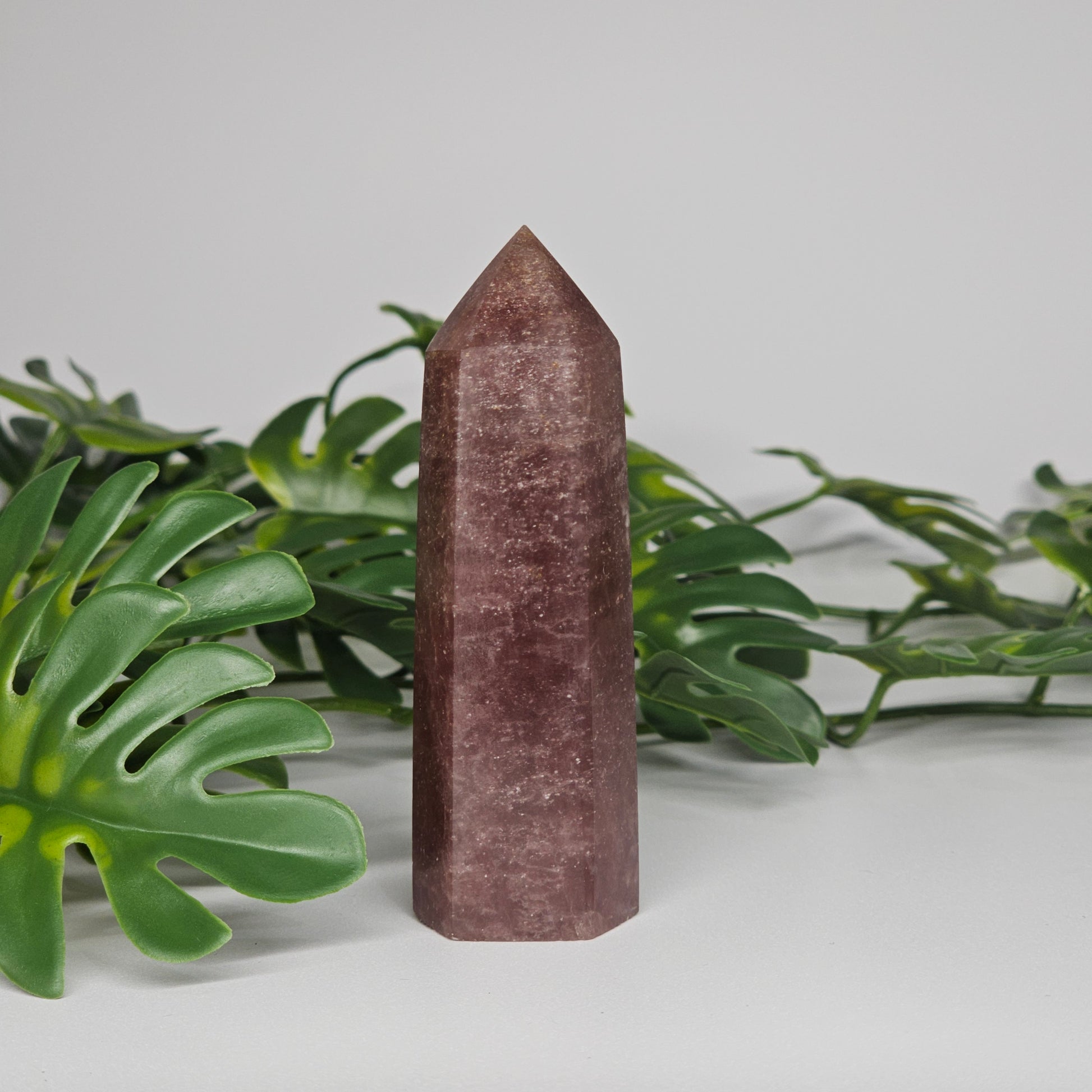 Dark strawberry quartz tower crystal showing rich pink colour and polished point