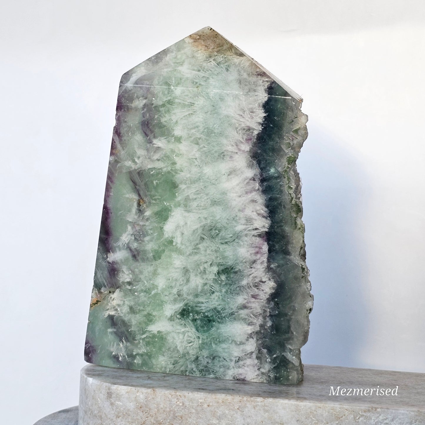 Flat polished side of Rainbow Feather Fluorite tower showcasing smooth finish and subtle feather-like inclusions.