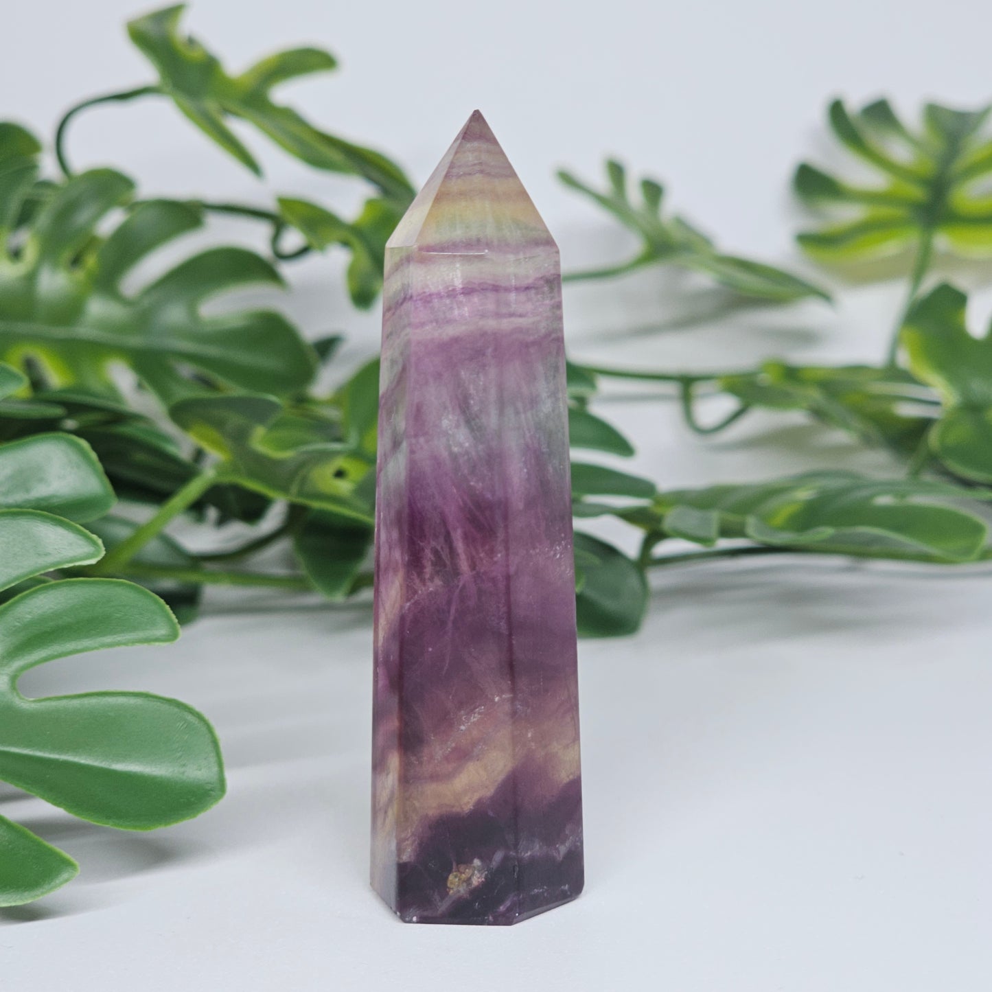 Fluorite tower detail with rich purple and soft green tones highlighting natural patterns and clarity