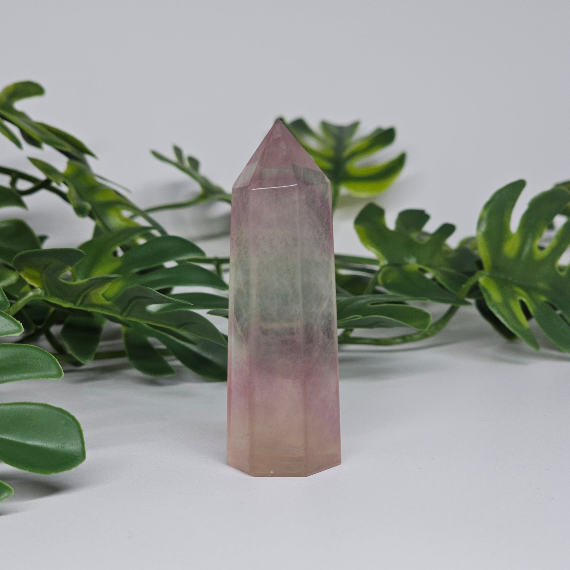 Fluorite crystal tower side profile showing layered banding with purple, green and yellow tones and polished finish