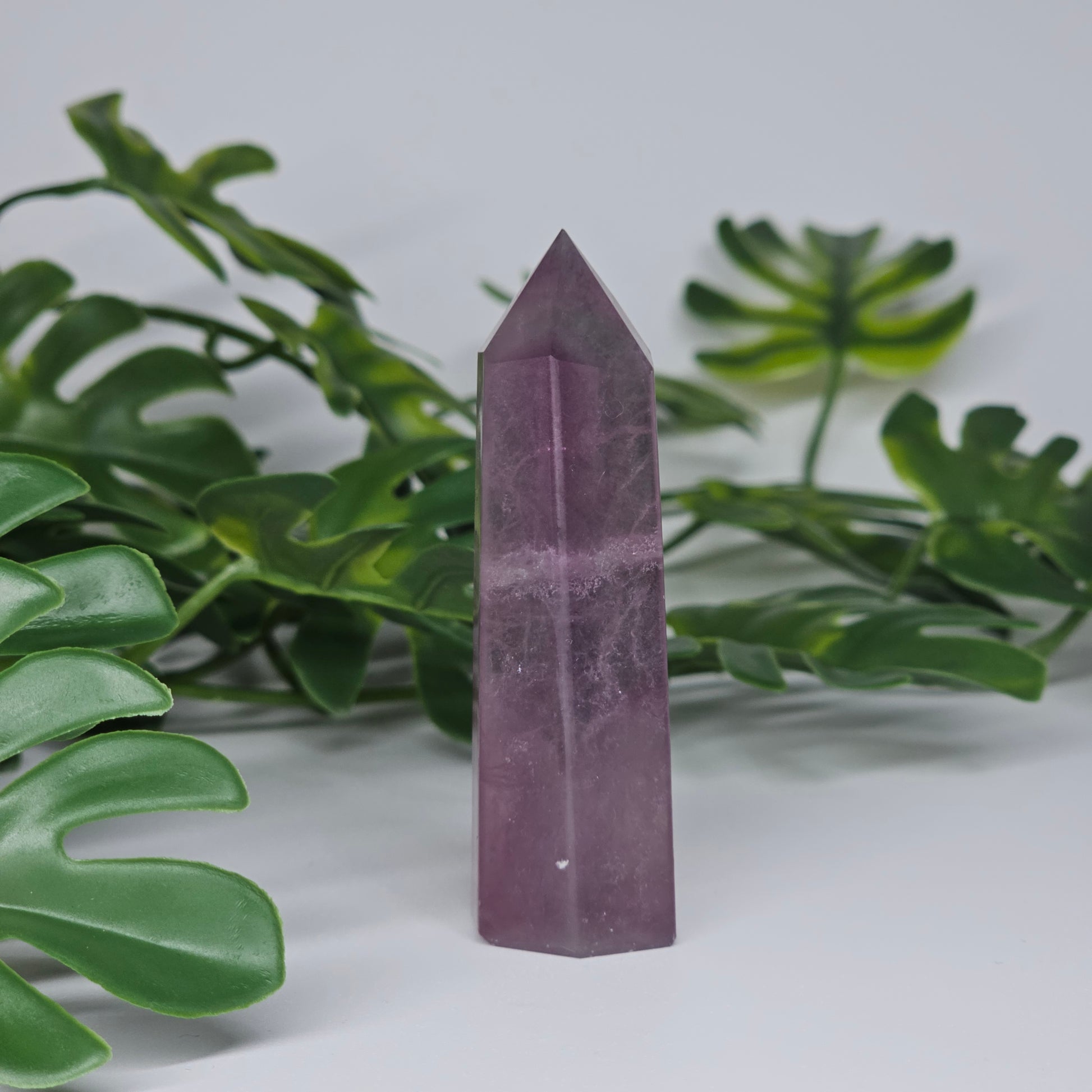 Fluorite crystal tower side profile showing purple tones and polished finish