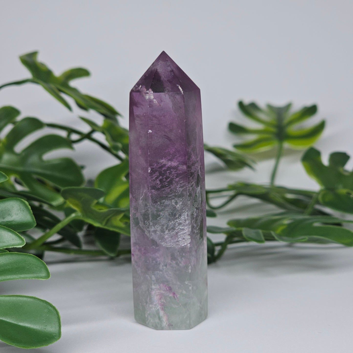 Fluorite crystal tower side profile showing icy purple and green tones and polished finish