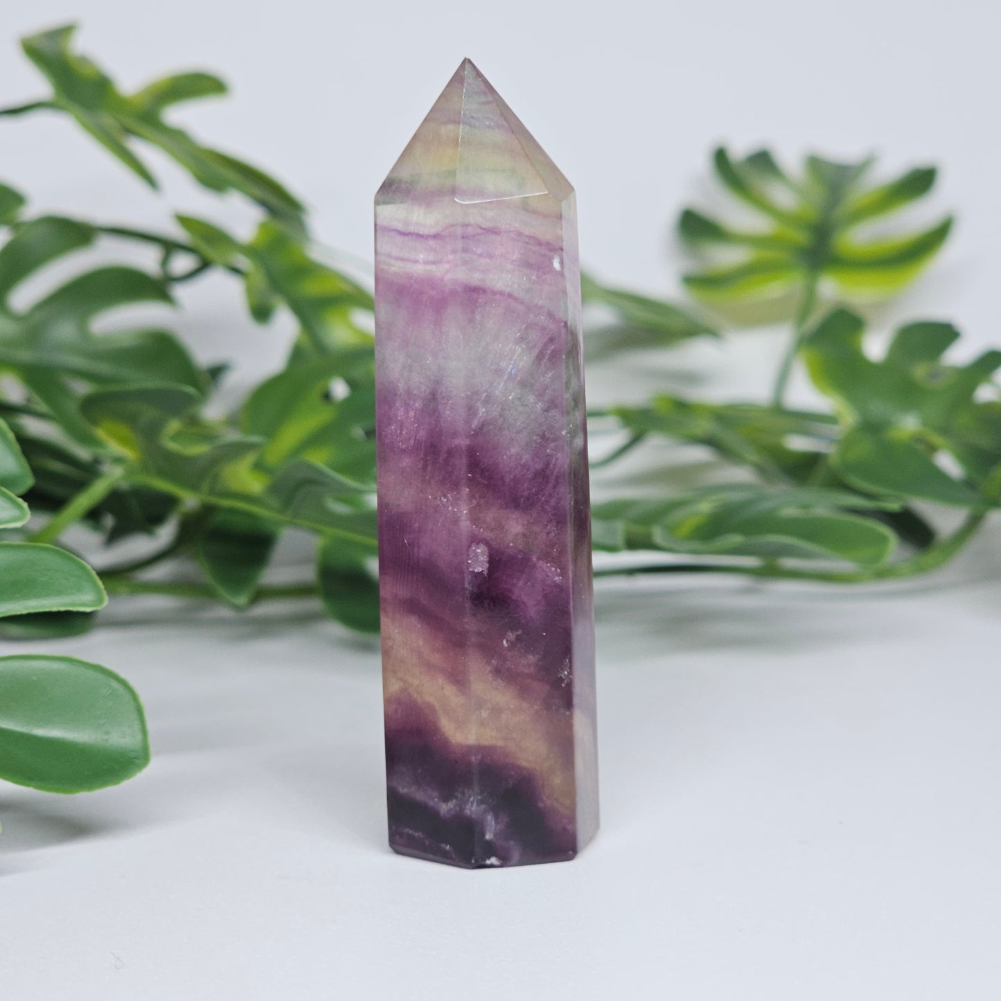 Fluorite tower with mixed colour banding in purple, green and yellow with smooth polished surface