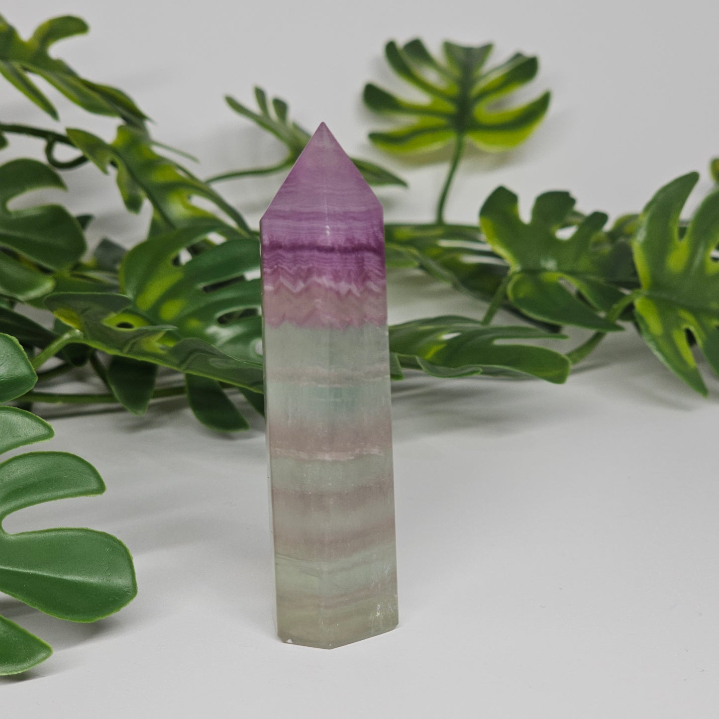 Fluorite tower with mixed colour banding in purple, green and yellow with smooth polished surface
