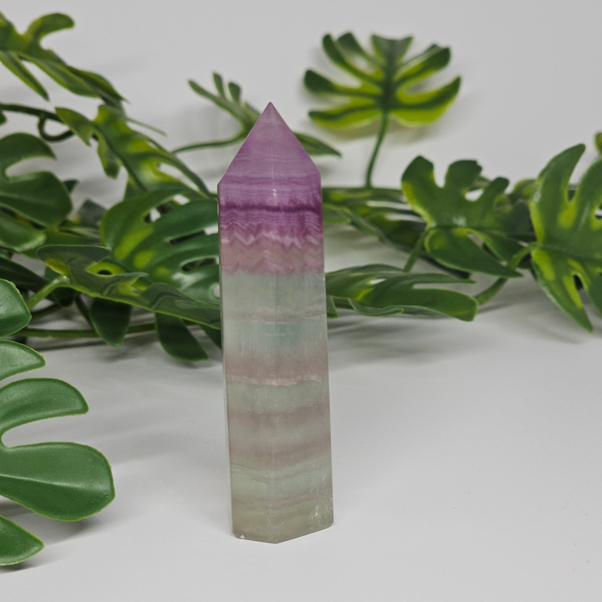 Fluorite tower with mixed colour banding in purple, green and yellow with smooth polished surface