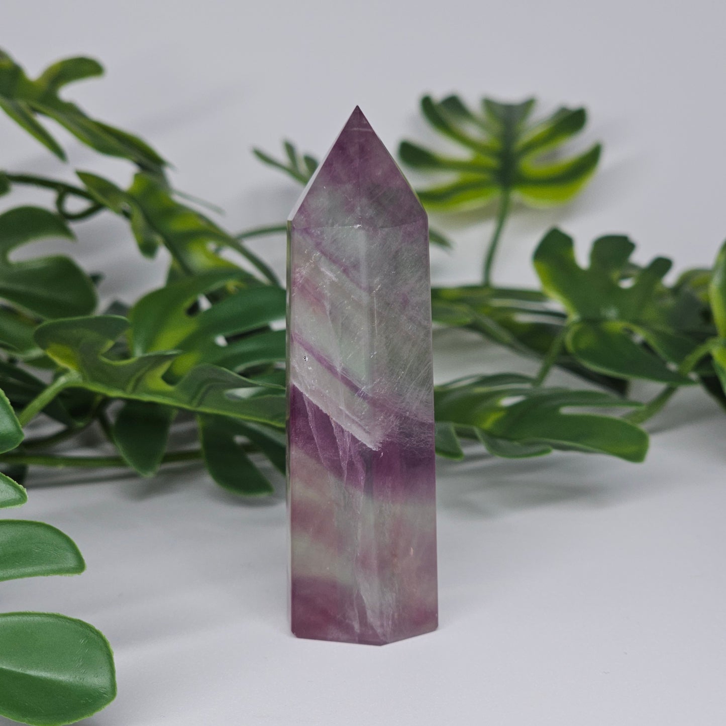 Fluorite tower with mixed colour banding in purple, green and yellow with smooth polished surface