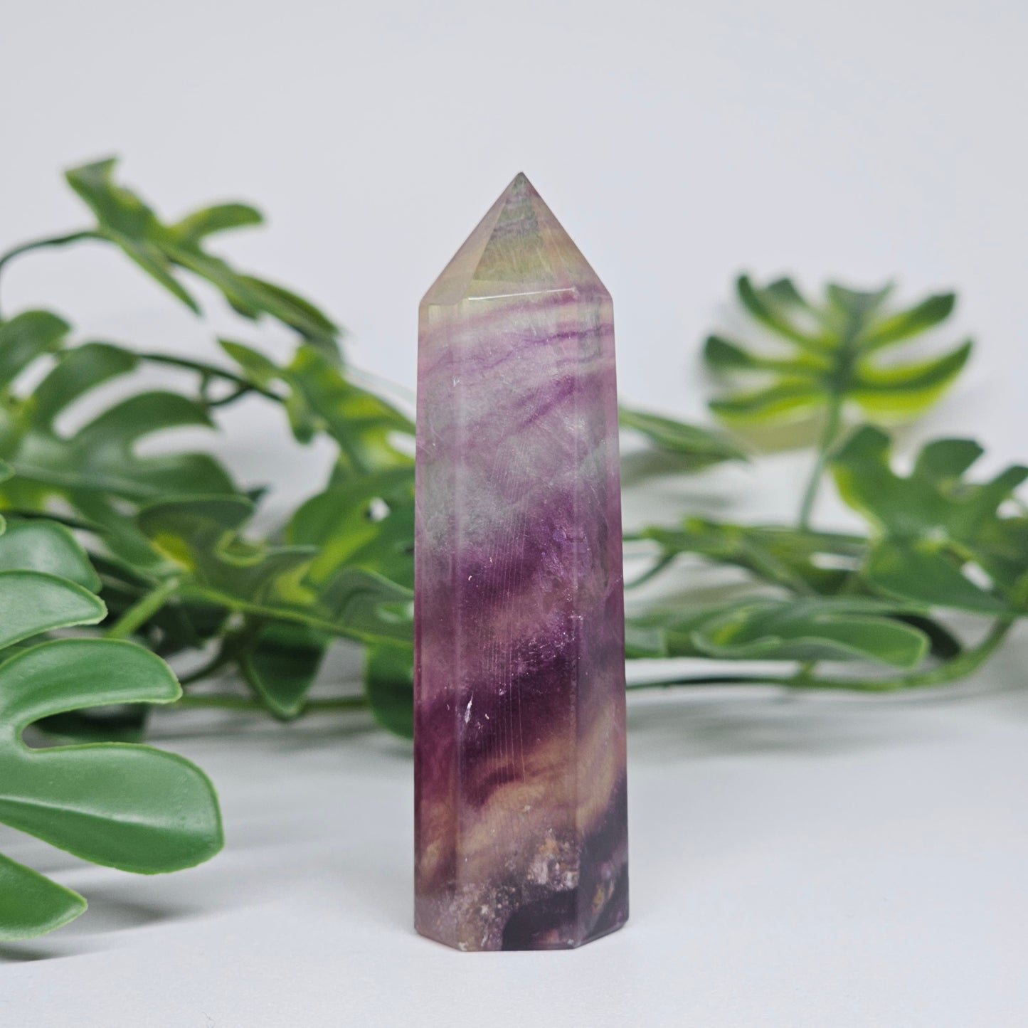 Fluorite tower with rich purple, soft green and yellow tones showing natural banding and polished finish