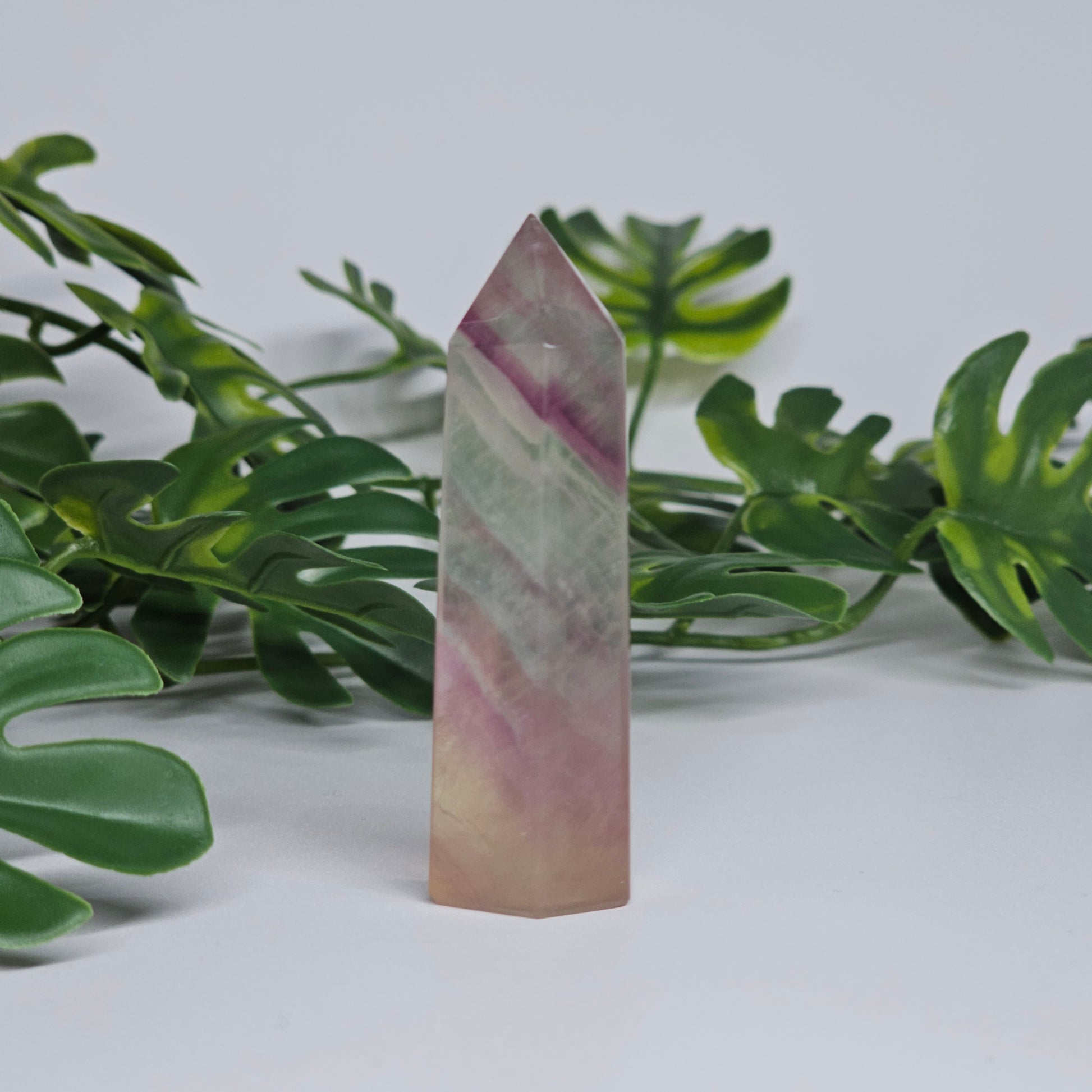Fluorite tower with soft purple, yellow and green tones showing natural banding and polished finish