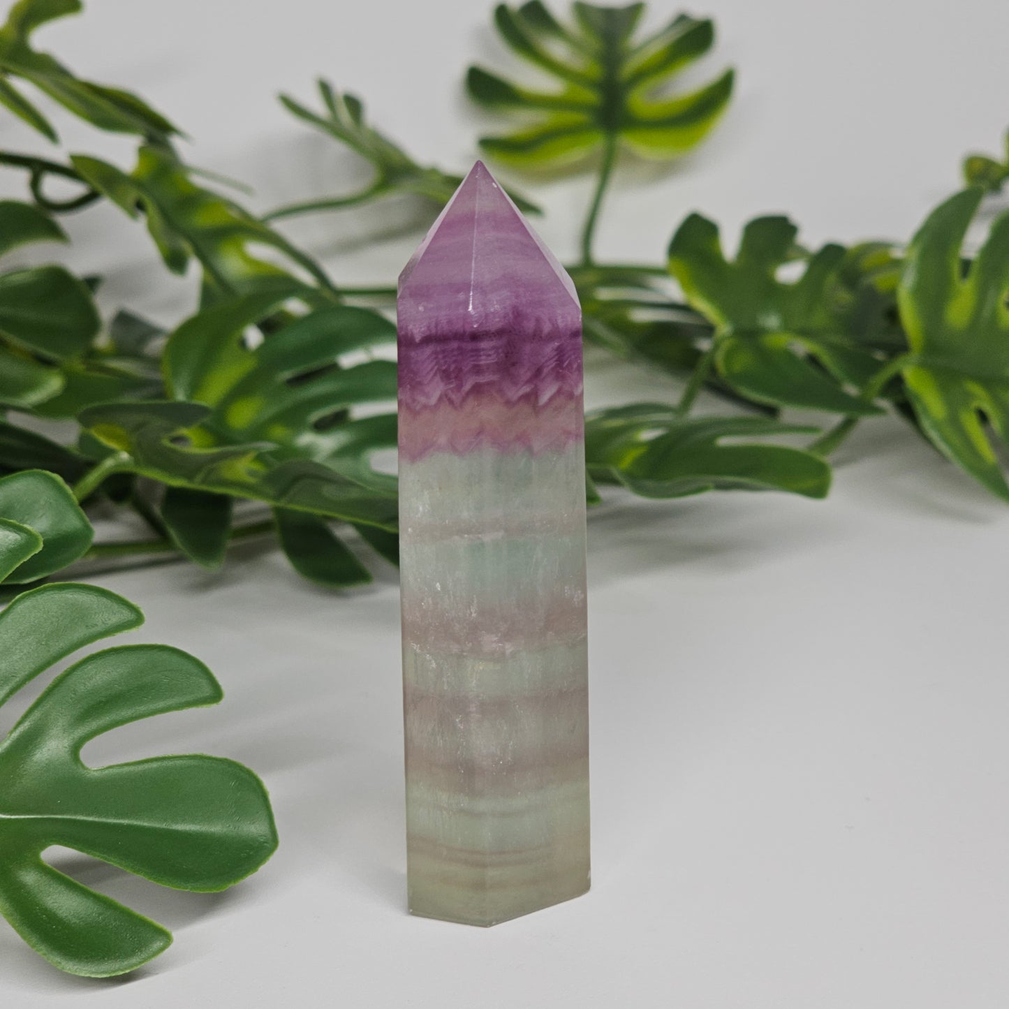 Fluorite tower with soft purple, yellow and green tones showing natural banding and polished finish