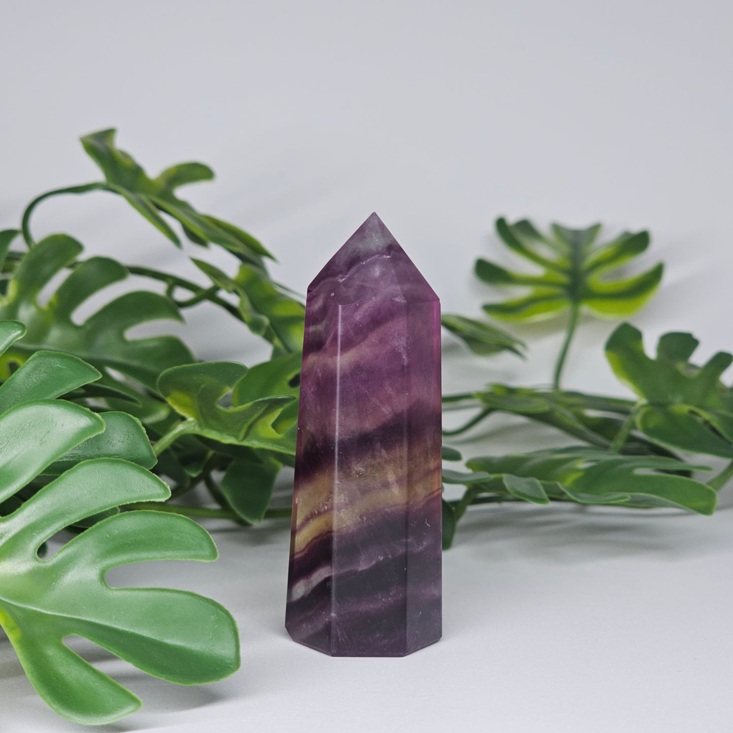 Fluorite tower with rich purple, yellow  andsoft green tones showing natural banding and polished finish