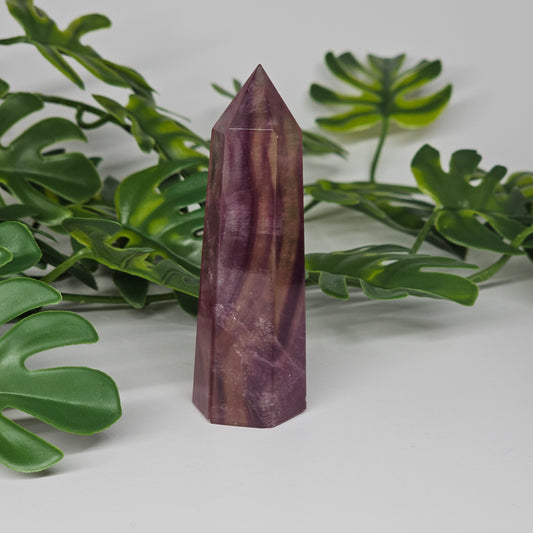 Fluorite tower with rich purple, yellow and soft green tones showing natural banding and polished finish