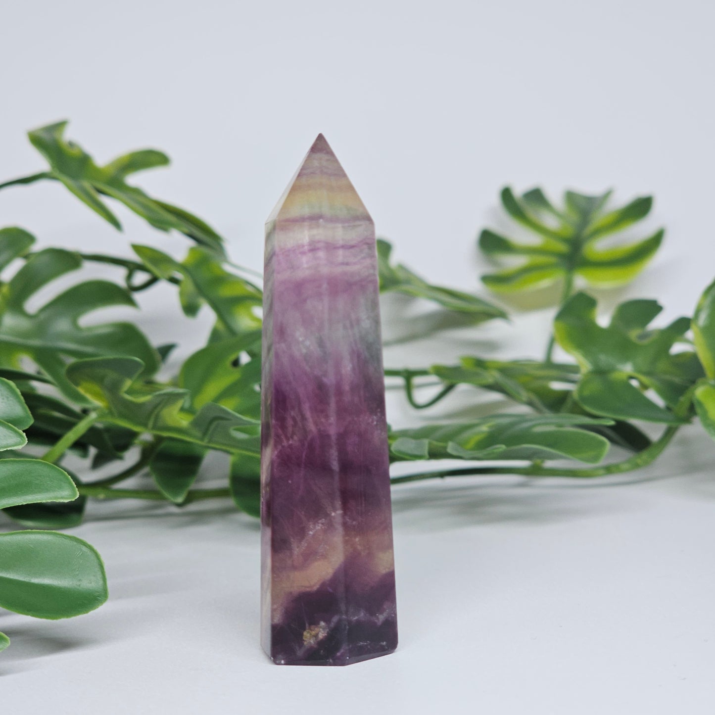 Fluorite crystal tower side view displaying layered colour zones and translucent natural formation