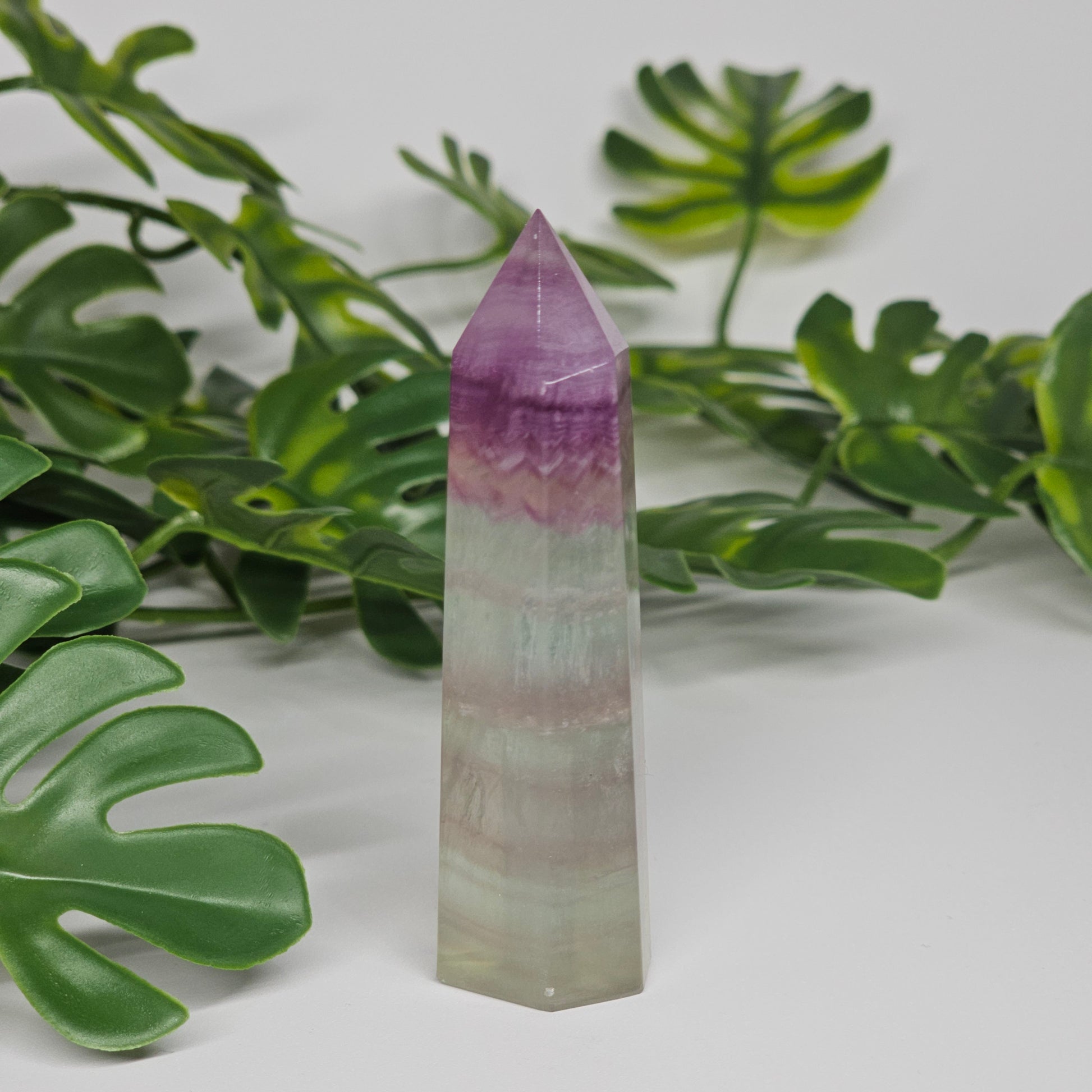 Fluorite crystal tower side view displaying layered colour zones and translucent natural formation