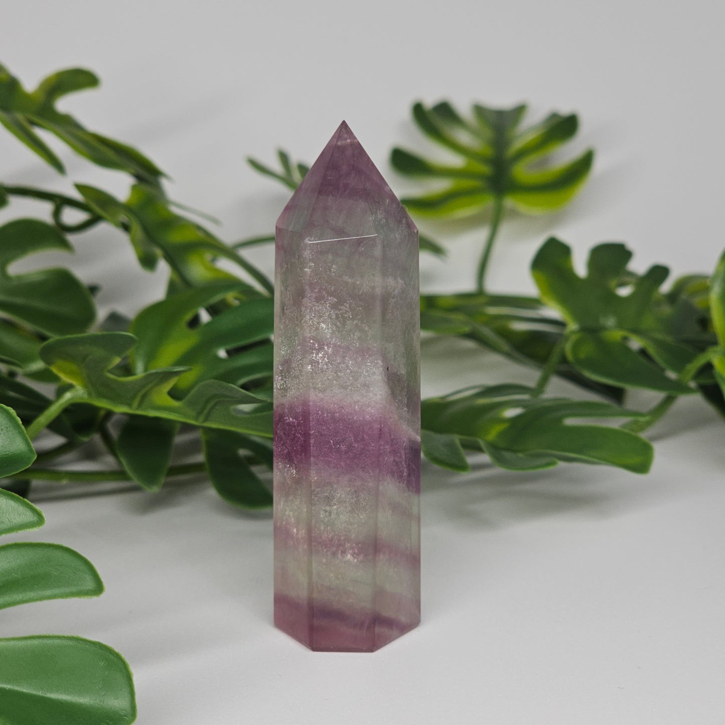 Fluorite crystal tower side view displaying layered colour zones and translucent natural formation