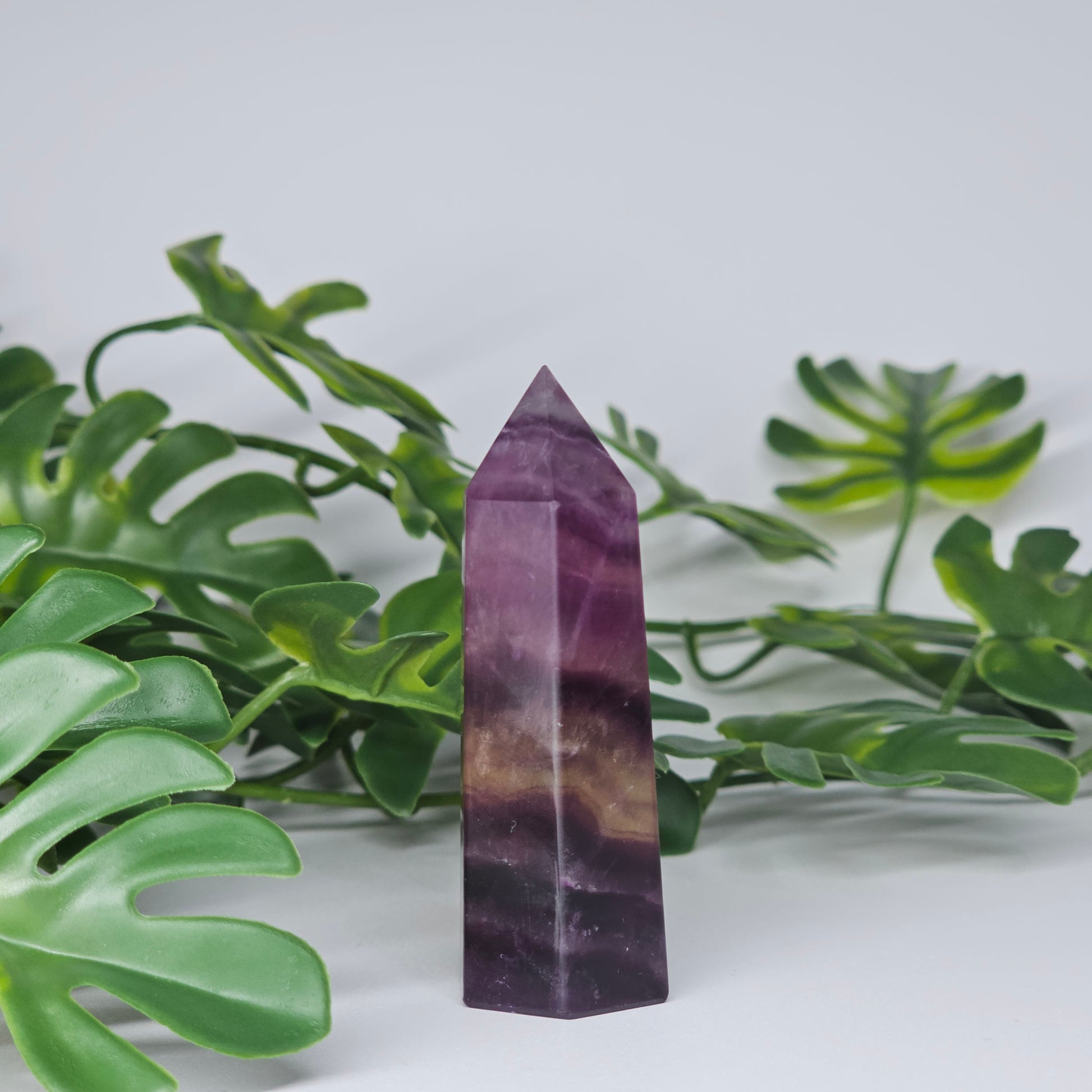 Fluorite crystal tower side view displaying layered colour zones and translucent natural formation
