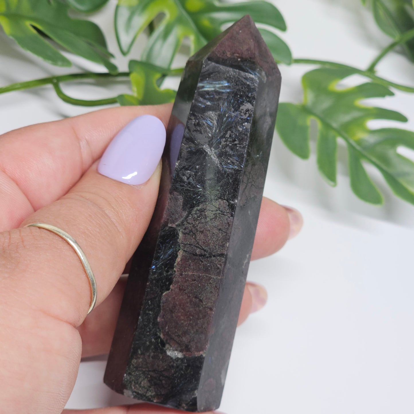 Garnet and Arfvedsonite crystal tower held in hand showing Arfvedsonite fireworks blades