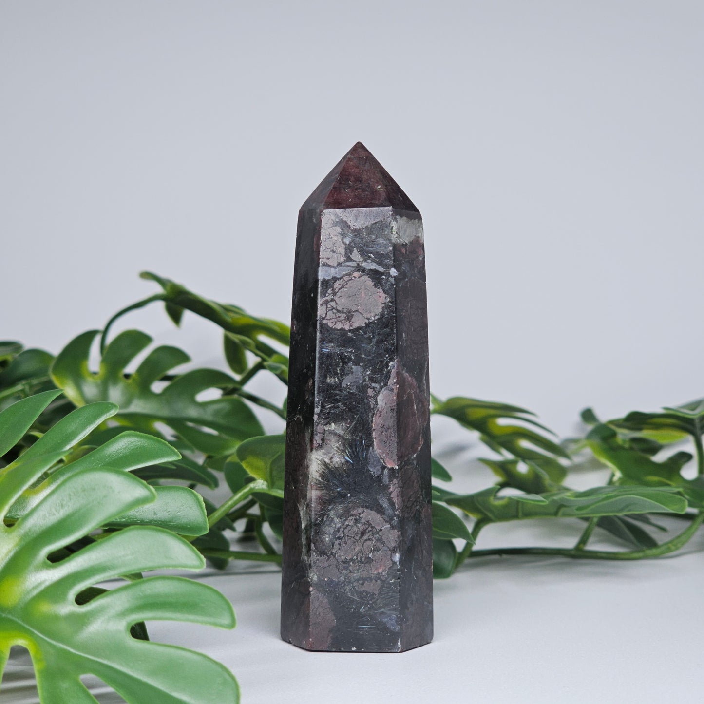 Garnet and arfvedsonite healing crystal tower with polished point and earthy tones