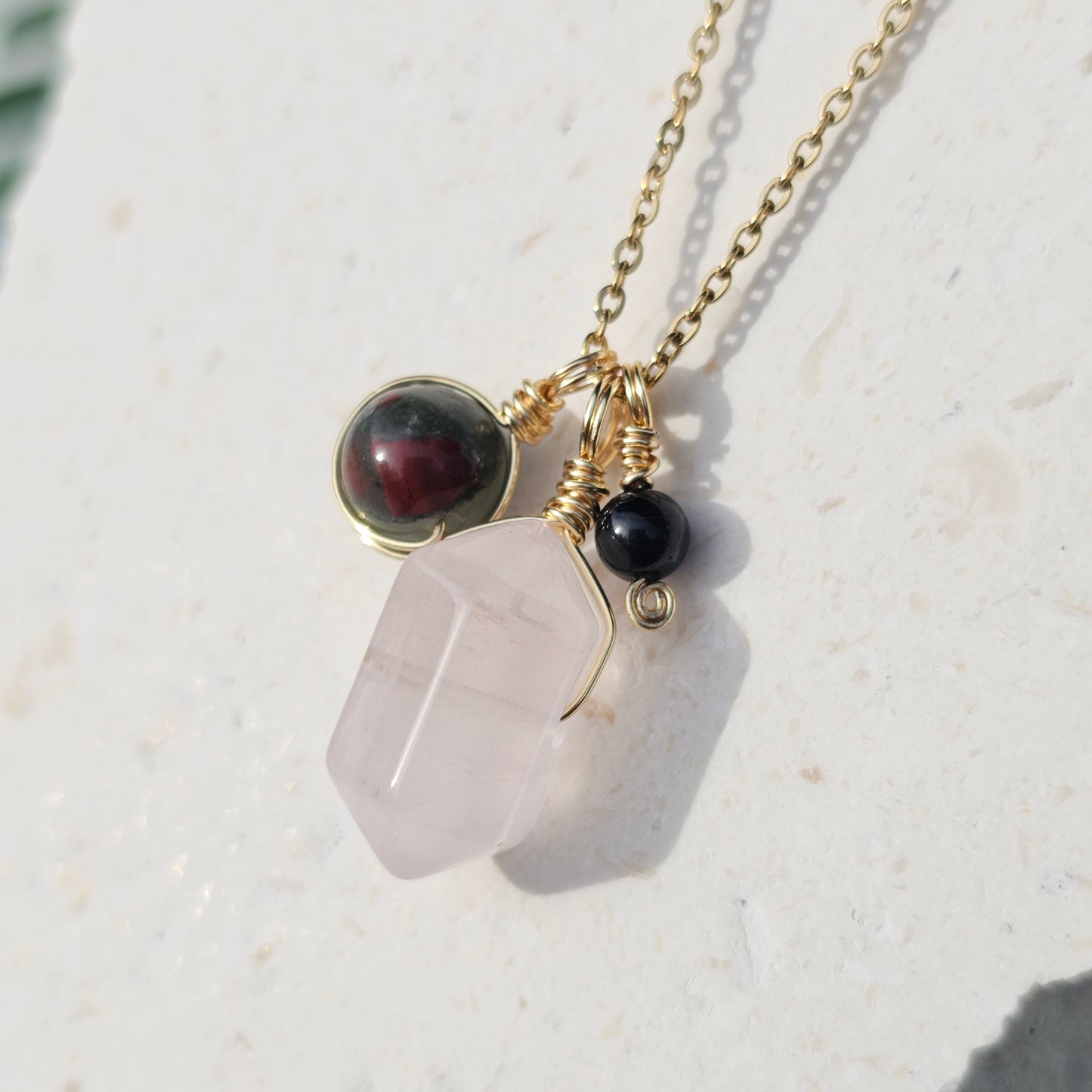 Front view of the Grounded Love Necklace featuring a Rose Quartz double terminated point Bloodstone Jasper bead and Black Tourmaline bead on a 45cm 18k gold plated stainless steel chain