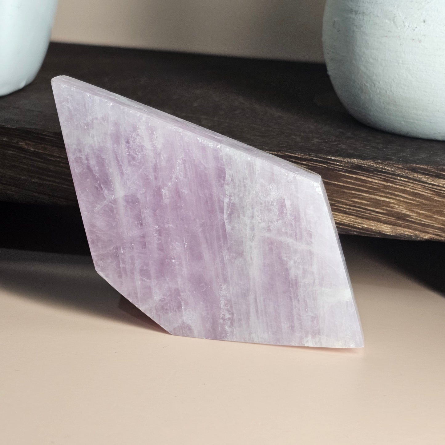 Self-standing Kunzite slab shown from a different angle, revealing unique contours and gentle colour variations.