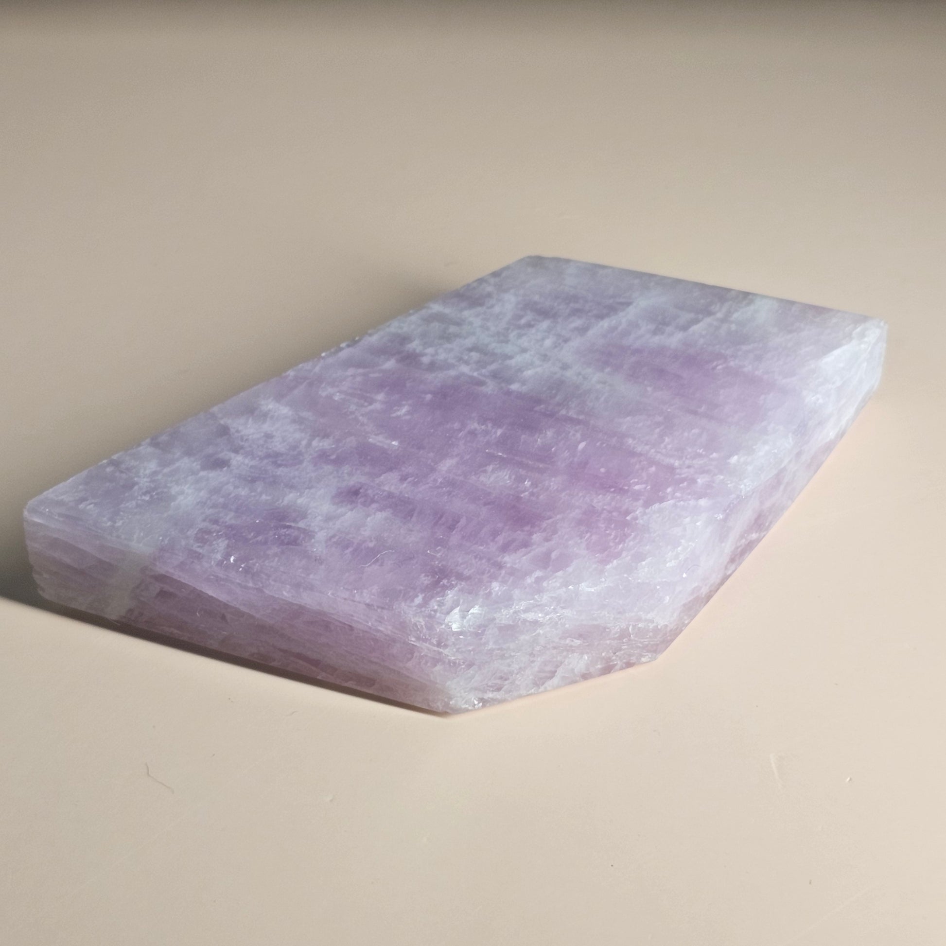 Polished Kunzite slab laid flat, showcasing soft colouring and smooth finish.