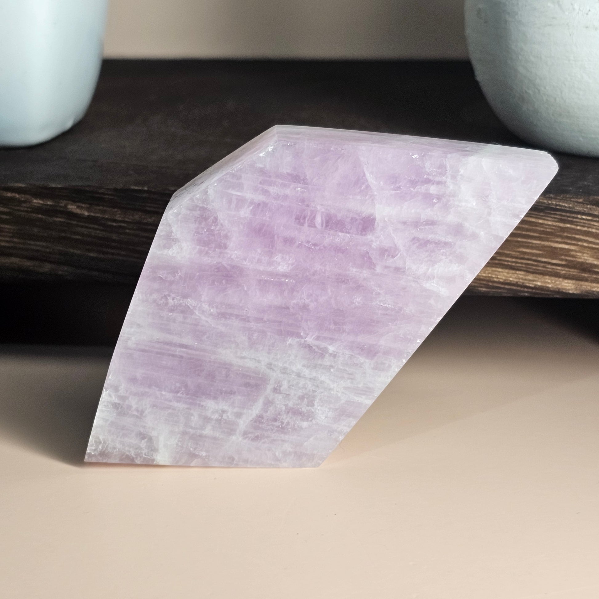 Kunzite slab displayed from another side angle, showcasing natural polish, soft glow, and smooth surface.