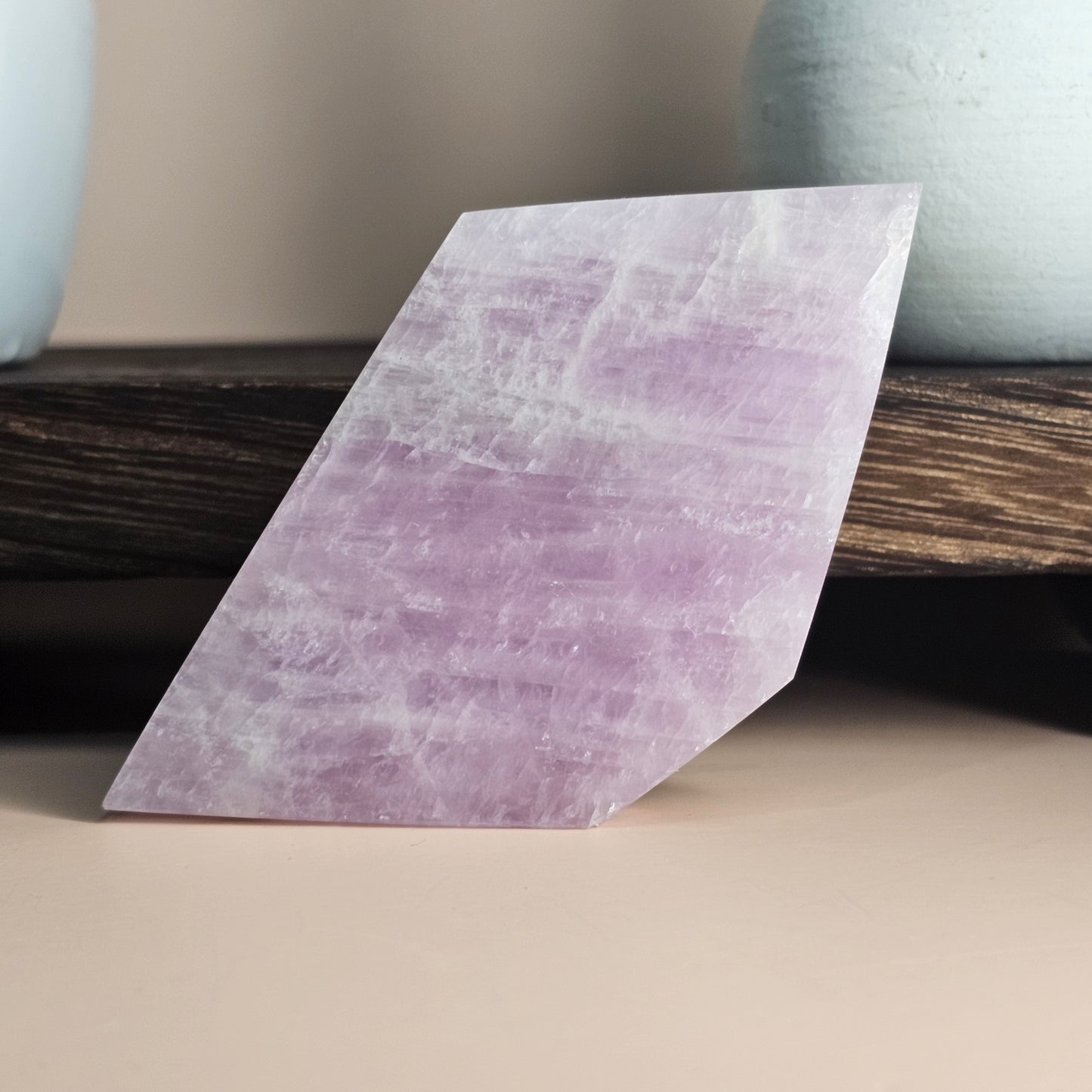 Self-standing Kunzite slab shown upright, displaying soft pink lilac tones and polished natural glow from a front-facing angle.