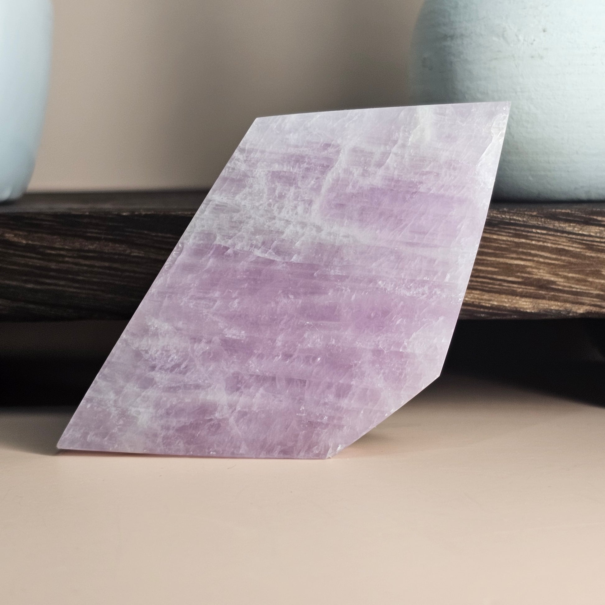 Self-standing Kunzite slab shown upright, displaying soft pink lilac tones and polished natural glow from a front-facing angle.