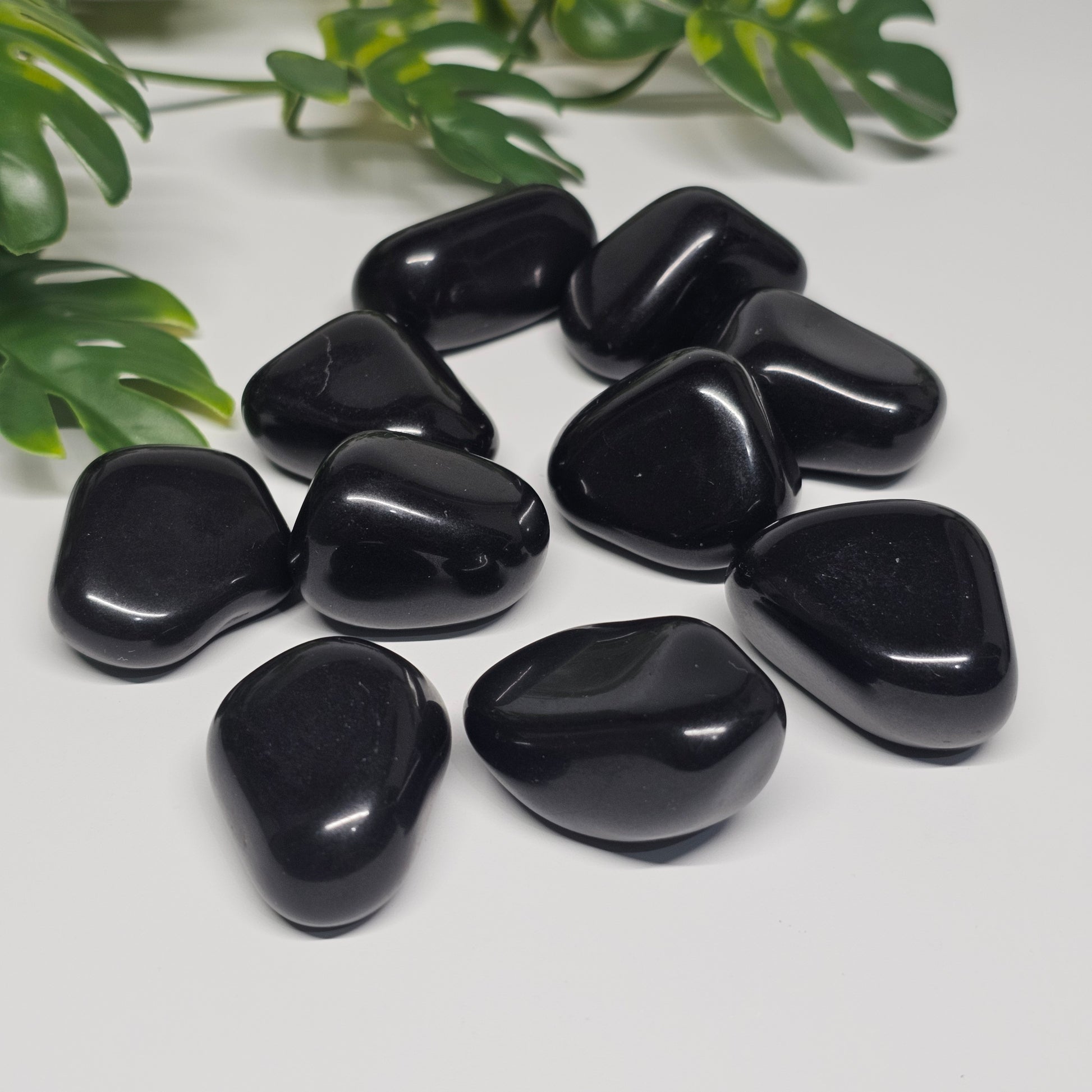 Large Black Tourmaline tumbles displayed on a flat surface, highlighting their natural form and powerful protective energy.
