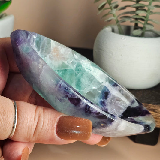 Side profile of the marquise Fluorite bowl in hand showing its slim curved edges, elongated shape, and smooth polished surface.