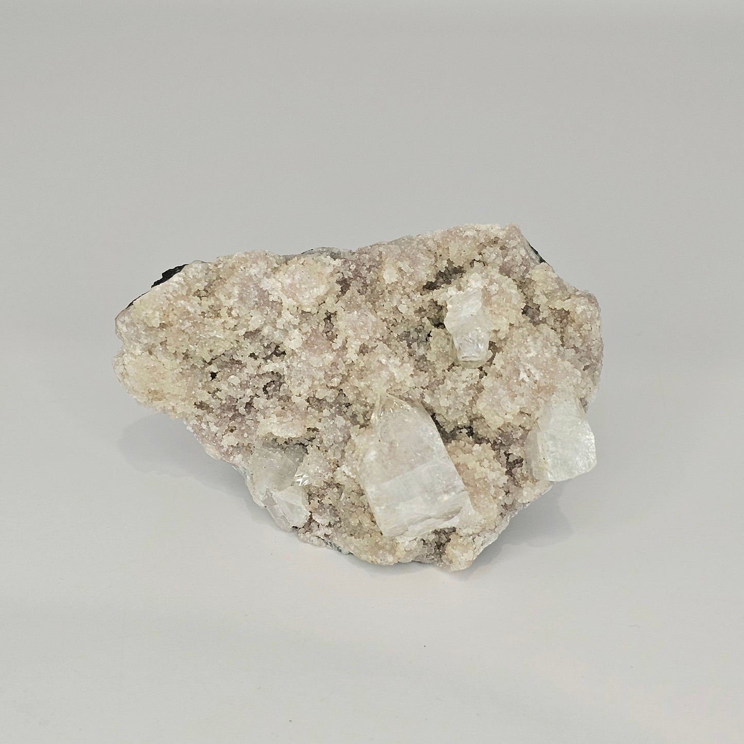 Detailed view of the natural cubic Apophyllite crystal formations with soft mauve tones and intricate mineral structure from India.
