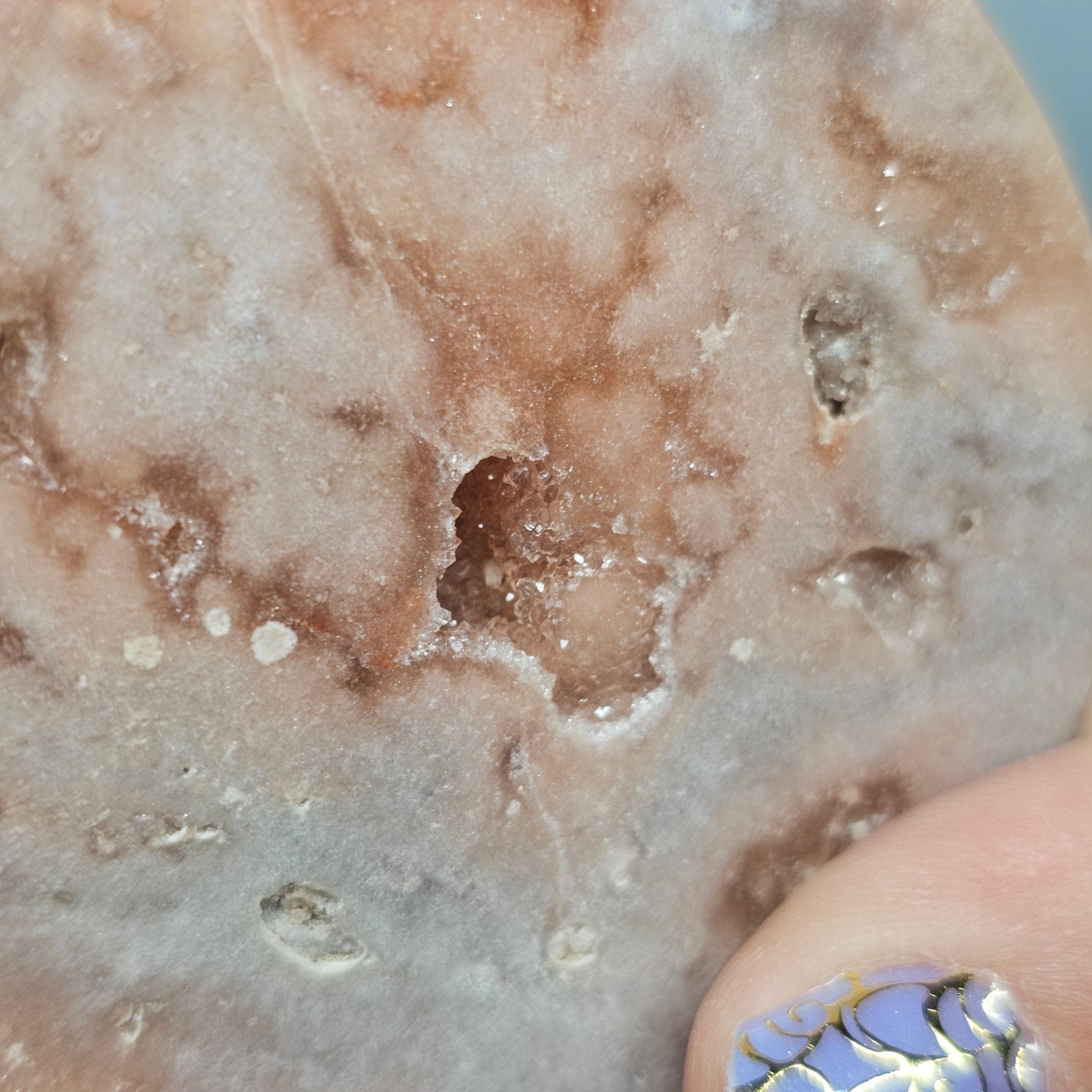 A close-up view of the natural crystalline pockets on the back of the carving, showing the raw texture of the Pink Amethyst.