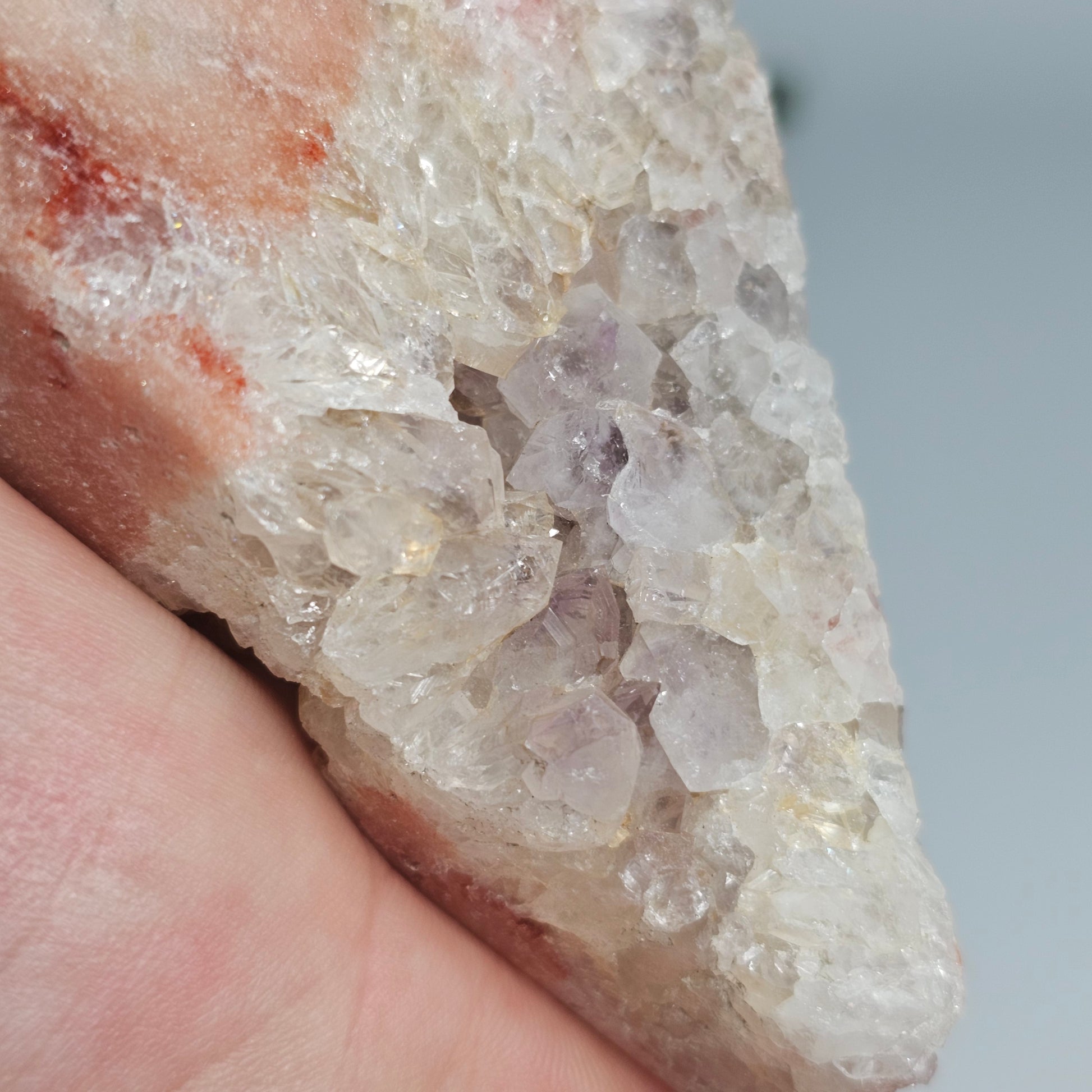 A close-up focusing on the traditional purple Amethyst inclusions nestled within the pink and red crystalline structure.