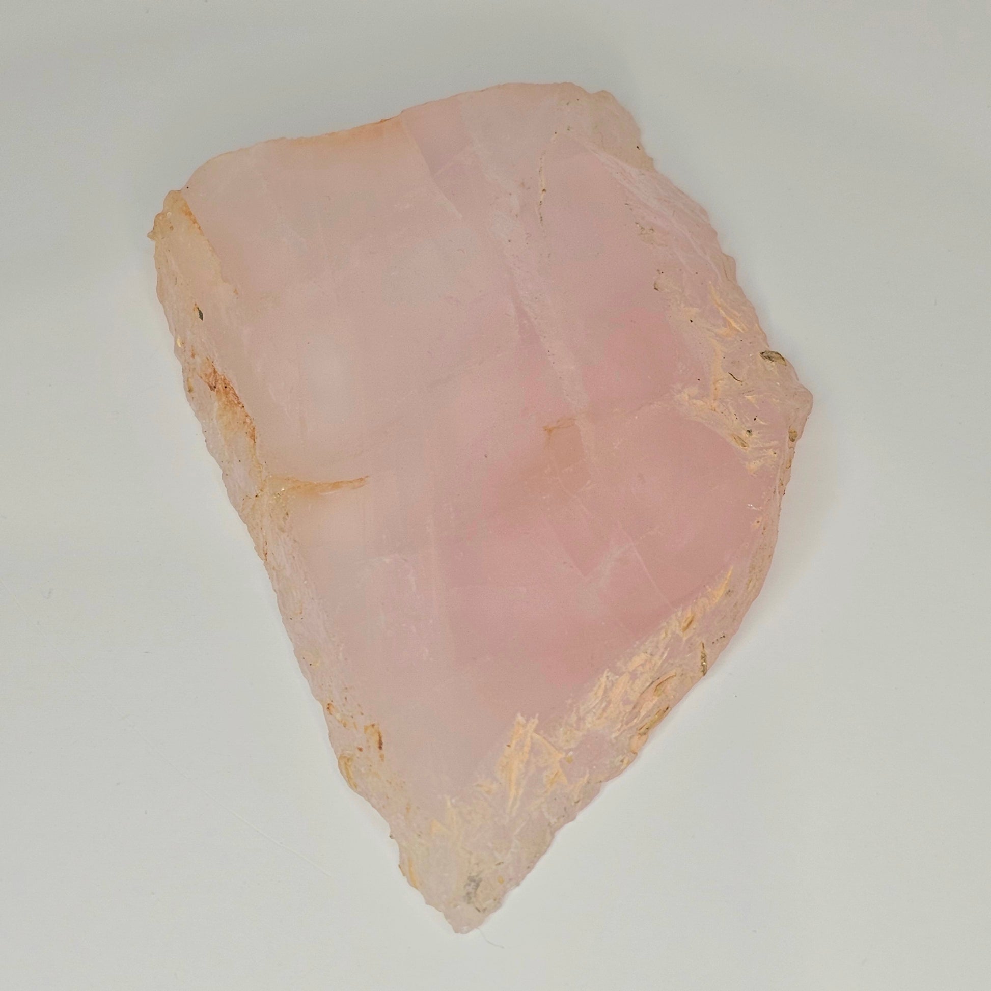 Polished translucent Rose Quartz slab displayed flat, highlighting soft pink colouring, natural internal rainbows, and smooth polished surface.