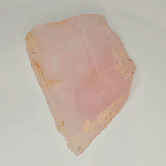 Polished translucent Rose Quartz slab displayed flat, highlighting soft pink colouring, natural internal rainbows, and smooth polished surface.