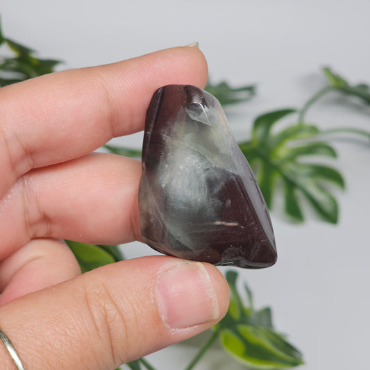 Polished Prehnite slab photographed in hand to show size, translucent green tones, and natural earthy inclusions with a smooth polished finish.