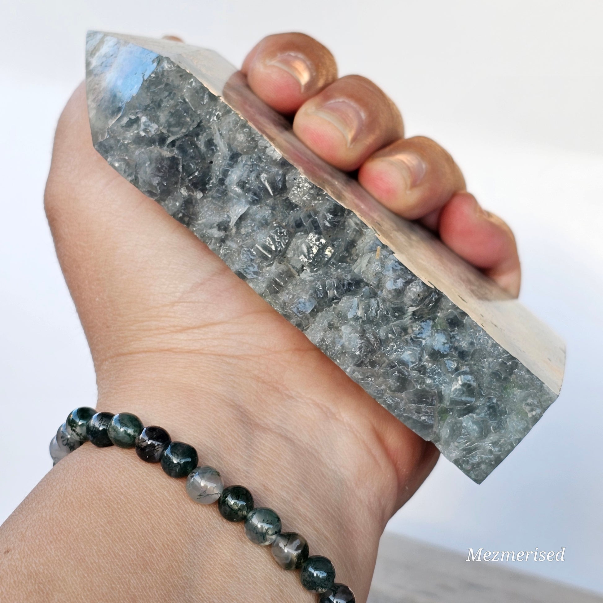 Rainbow Feather Fluorite tower held in hand to show size, colour variation and natural crystal features.